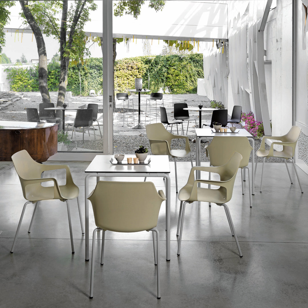 Modern gray and white cafe setting featuring cream-colored chairs around sleek, minimalist tables.