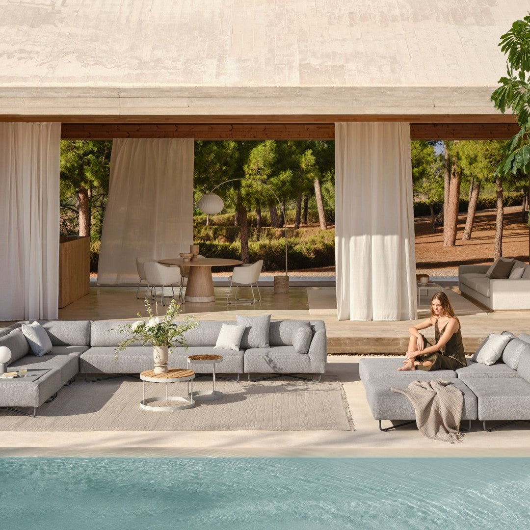 Modern outdoor sofa set in soft gray tones, featuring minimalist design and subtle textured patterns by the pool.