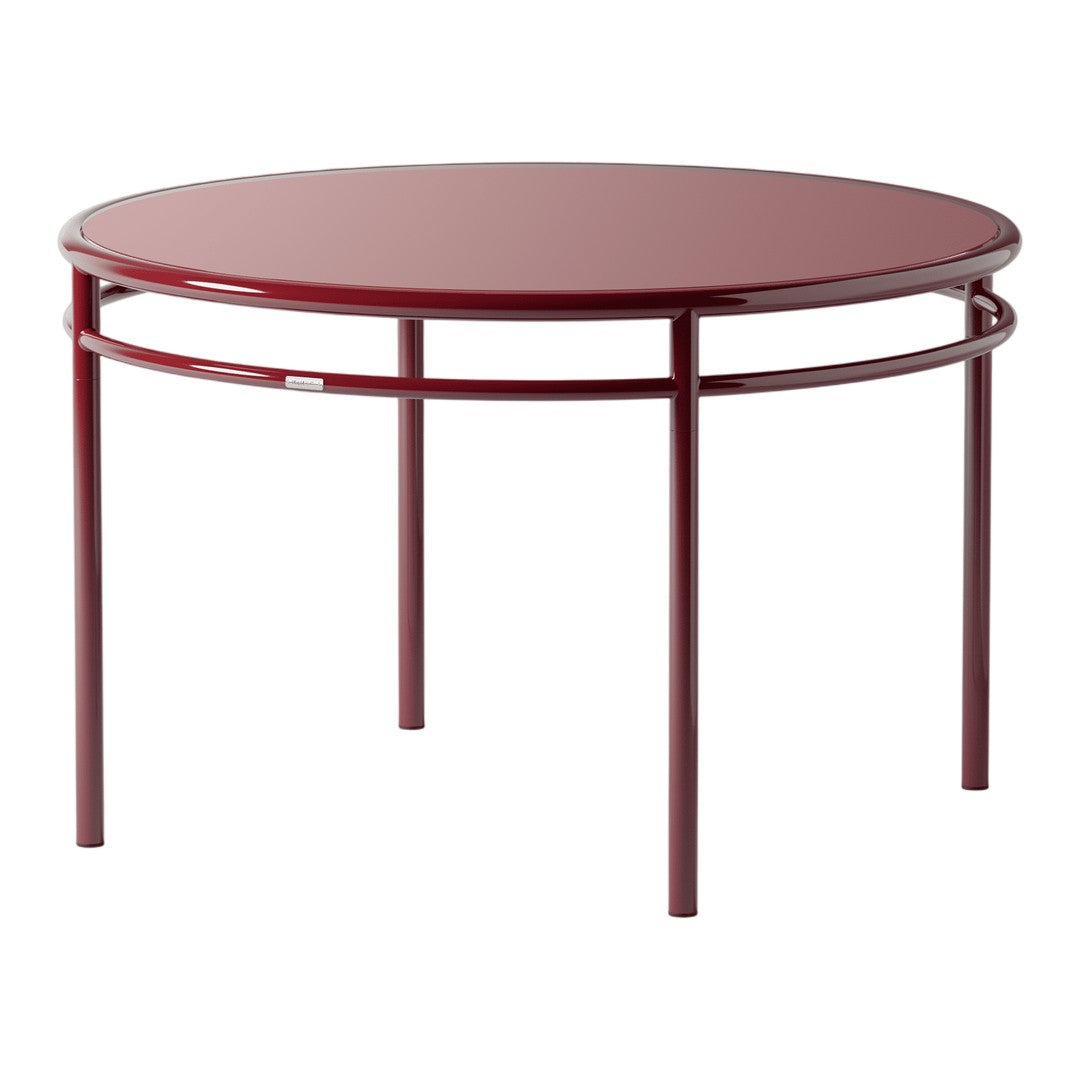 Round table featuring a sleek maroon top and minimalist metal frame. Perfect for modern decor.