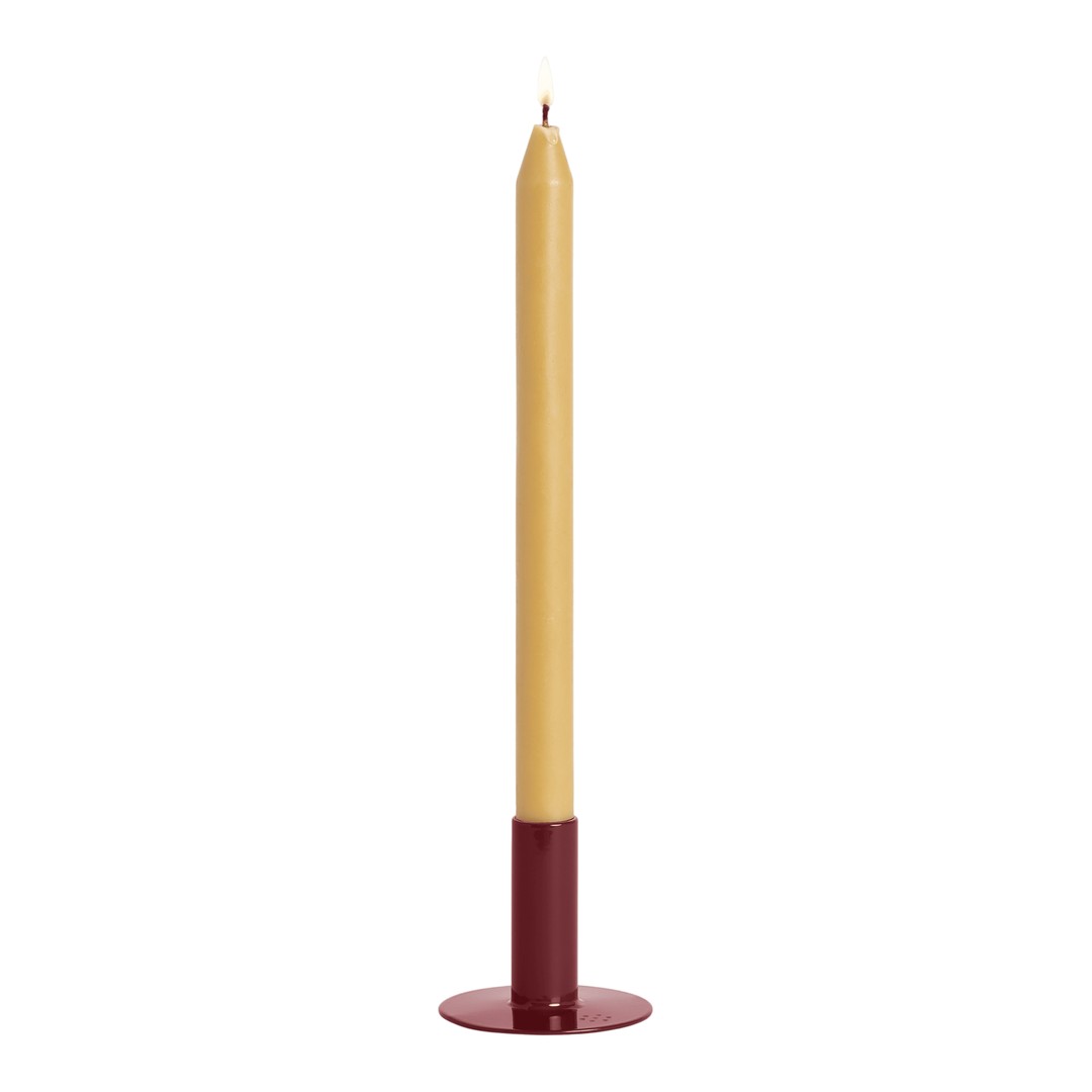 Tall yellow candle in a sleek round burgundy holder, perfect for enhancing cozy decor.
