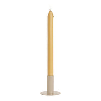 Tall yellow candle with a smooth finish, set in a minimalist beige holder. Ideal for elegant decor.