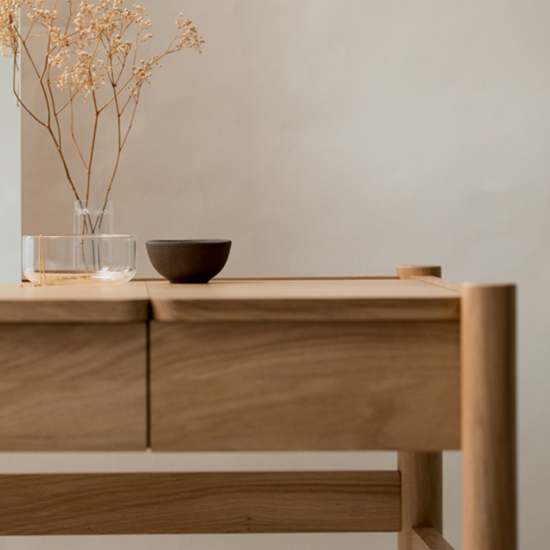 Natural wood table with a smooth finish, paired with earthy tones and subtle textures, showcasing a minimalist design.