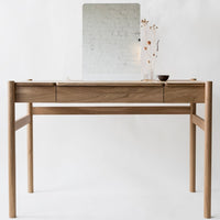 Light wood desk with a natural finish, featuring smooth lines and a minimalist design, paired with a simple reflective mirror.