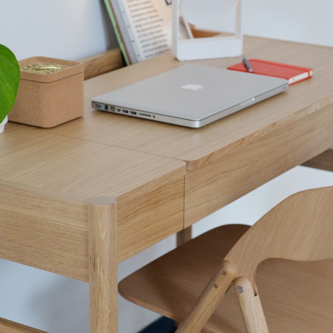 Light wood desk with a smooth finish, featuring natural grain patterns, complemented by soft neutral tones.