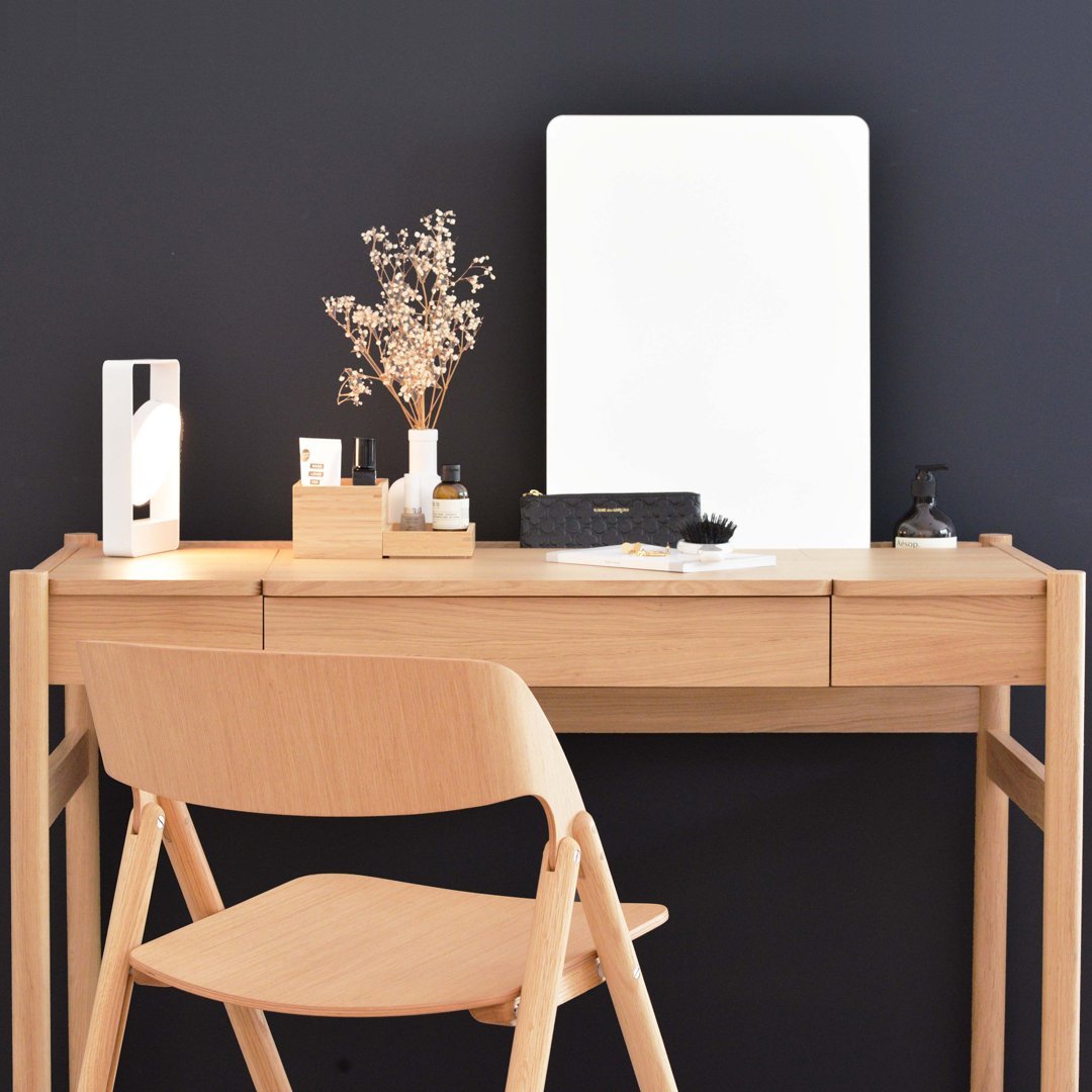Wooden desk with light oak finish, white accents, and a dark gray wall background. Elegant minimalistic decor.