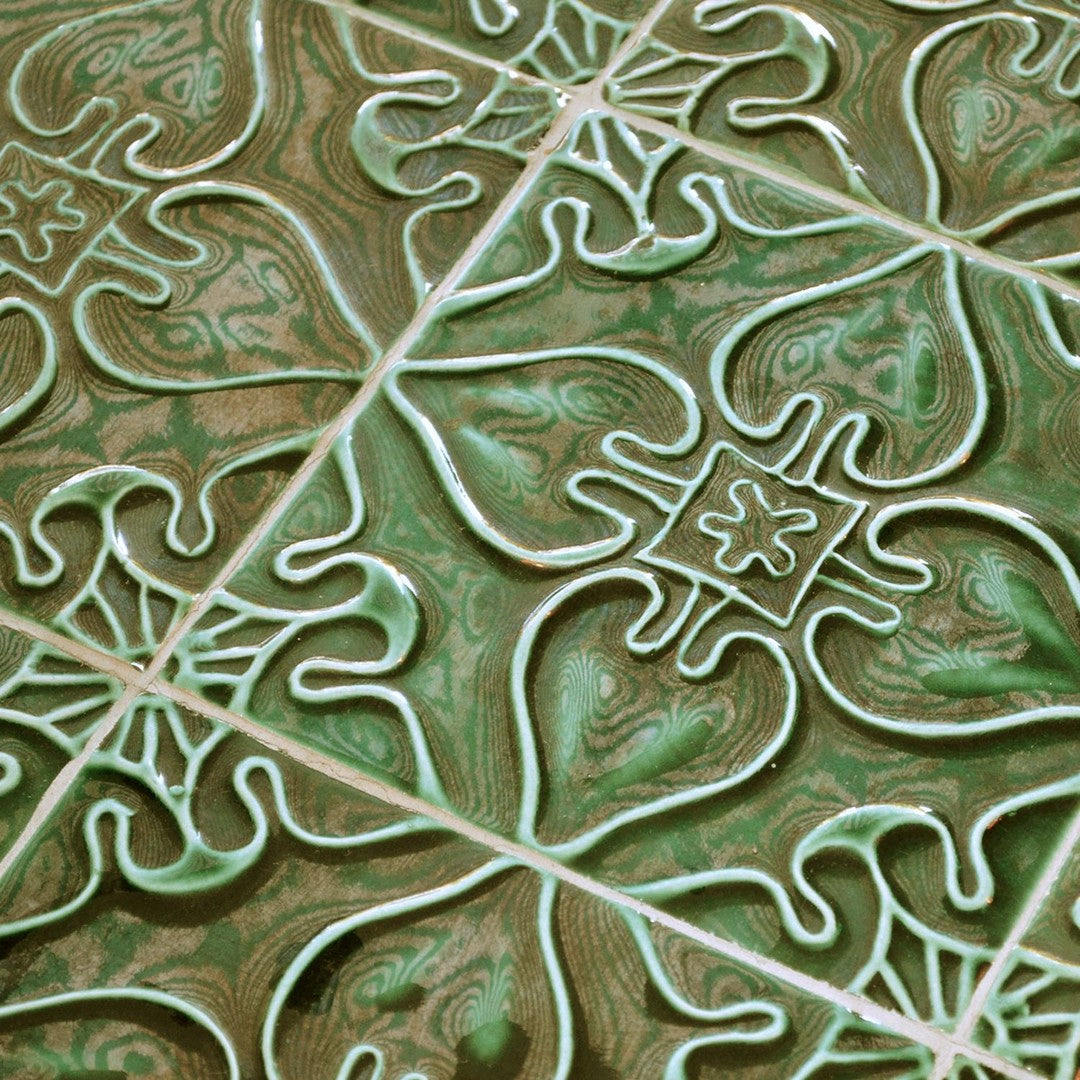 Detailed green patterned tiles with white intricate designs and swirling textures, perfect for home decor.