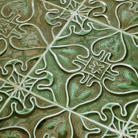 Detailed green patterned tiles with white intricate designs and swirling textures, perfect for home decor.
