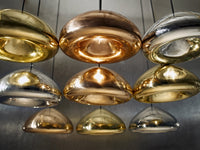 "Stylish pendant lights in gold, silver, and bronze finishes, showcasing sleek, modern designs and reflective surfaces."