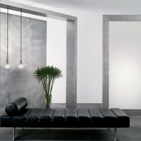 Sleek black leather bench with vertical lines, set against a minimalist gray and white background, complemented by greenery.