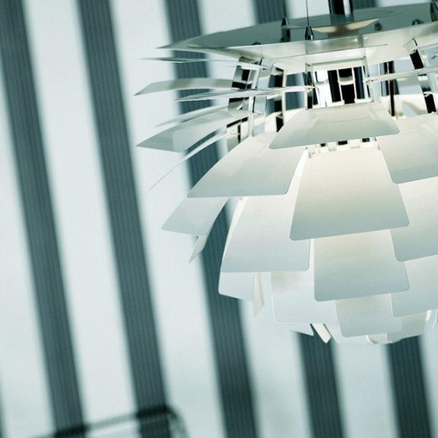 Modern white pendant lamp with layered geometric shapes, contrasting against soft gray striped background.