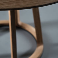 Natural wood tones with smooth, curved lines and a minimalist design on a soft gray background.