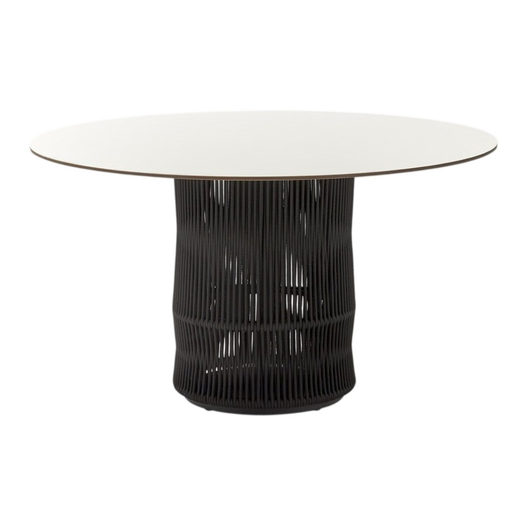 Modern round dining table with a sleek white top and textured black base, featuring vertical line patterns.