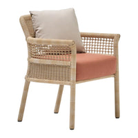 Beige wicker armchair with salmon pink cushion and light beige throw pillow, featuring a modern, natural design.
