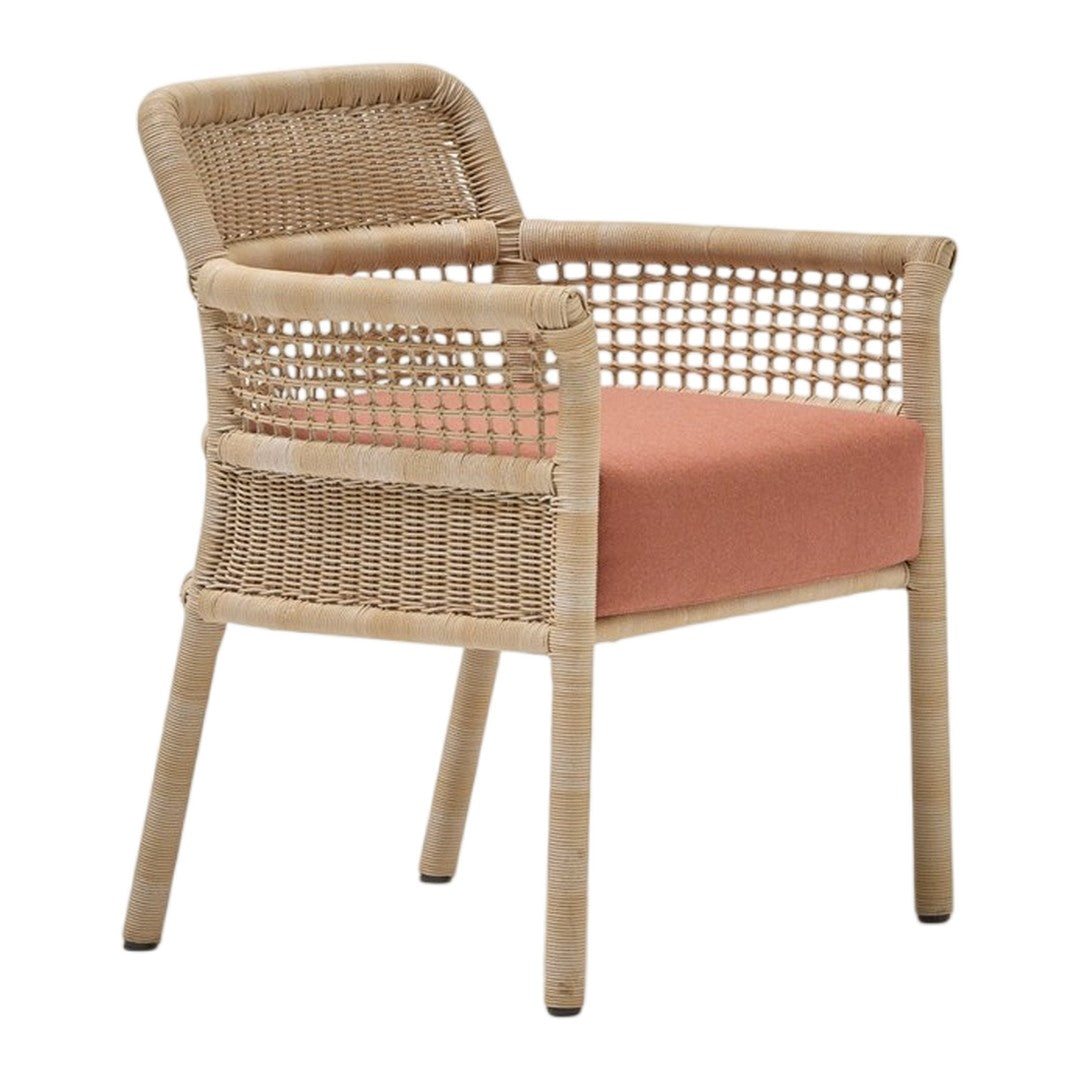 Woven rattan chair with a natural finish and soft coral fabric cushion, featuring a modern, minimalist design.