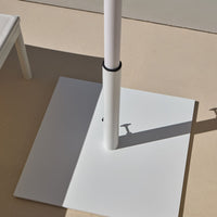 White patio umbrella base with smooth, matte finish and sleek, modern design. Perfect for outdoor settings.