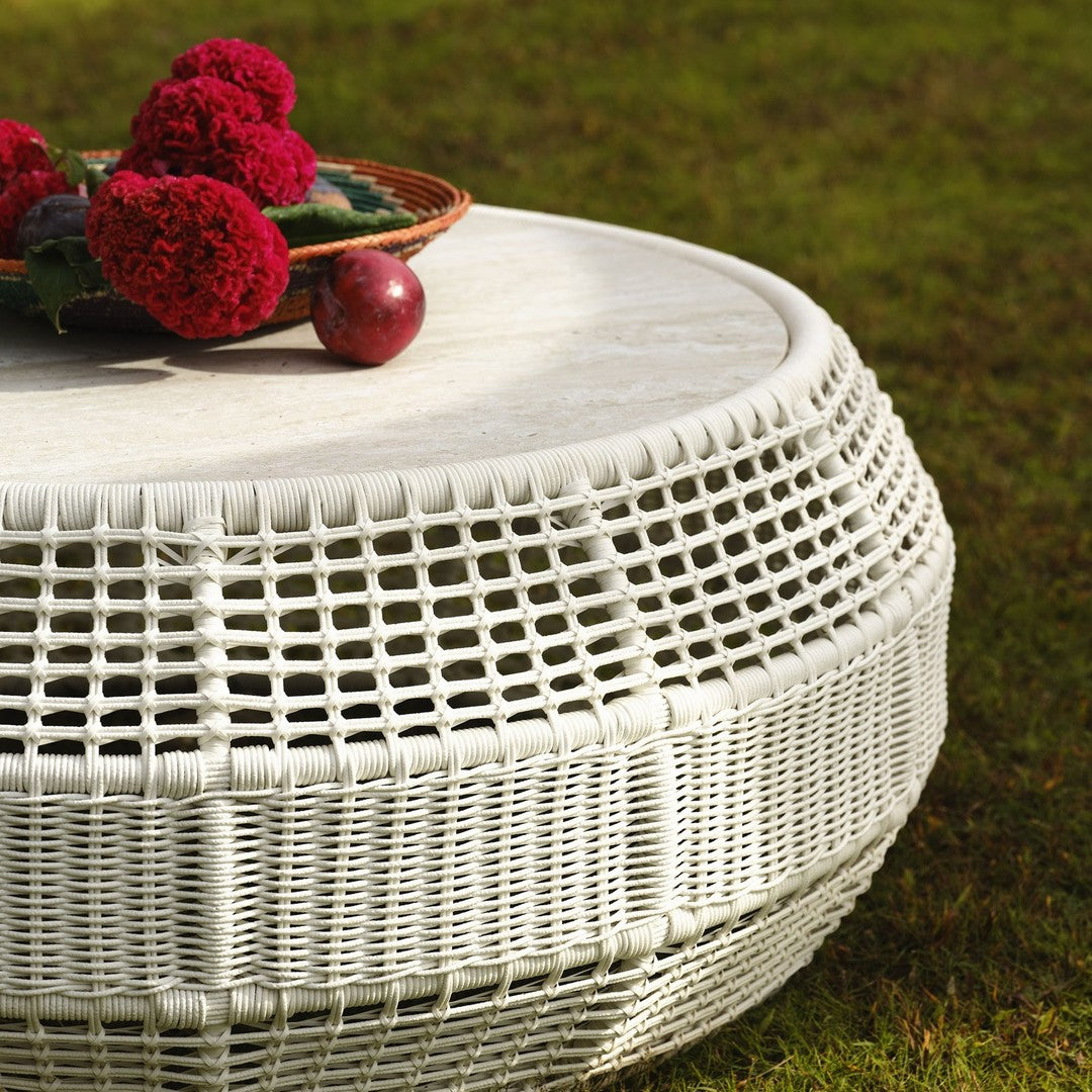 White woven coffee table with circular design, featuring a textured pattern and adorned with red flowers and fruits.