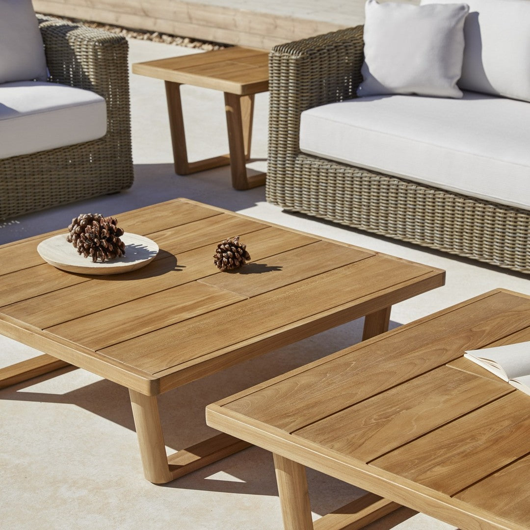 Natural wood grain coffee tables with a warm brown finish, paired with neutral-colored cushions in a cozy outdoor setting.