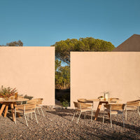 "Neutral beige walls with wooden outdoor furniture; warm earthy tones and natural textures create a serene atmosphere."