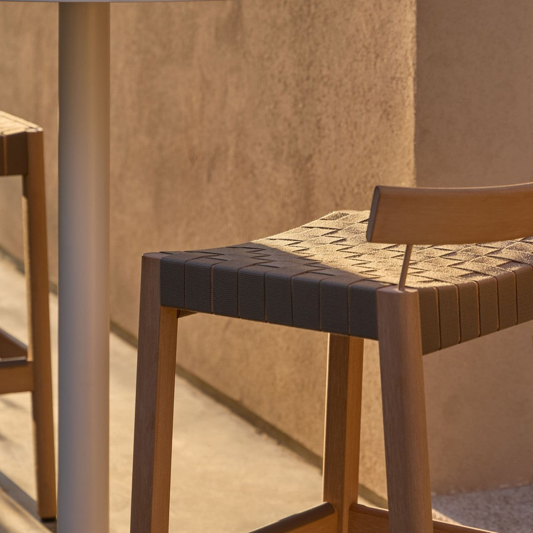 Natural wood barstool with a woven beige pattern against a warm, minimalistic backdrop. Stylish and modern design.