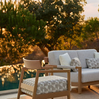 "Modern outdoor seating in soft gray with geometric patterns, complemented by neutral cushions and a natural wood frame."