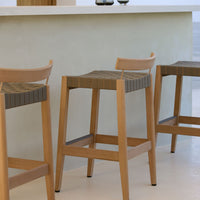 Wooden bar stools with natural oak finish and textured gray seat patterns, ideal for modern interiors.