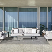 Modern outdoor seating in soft grey tones with white cushions, featuring clean lines and minimalistic design against a serene backdrop.