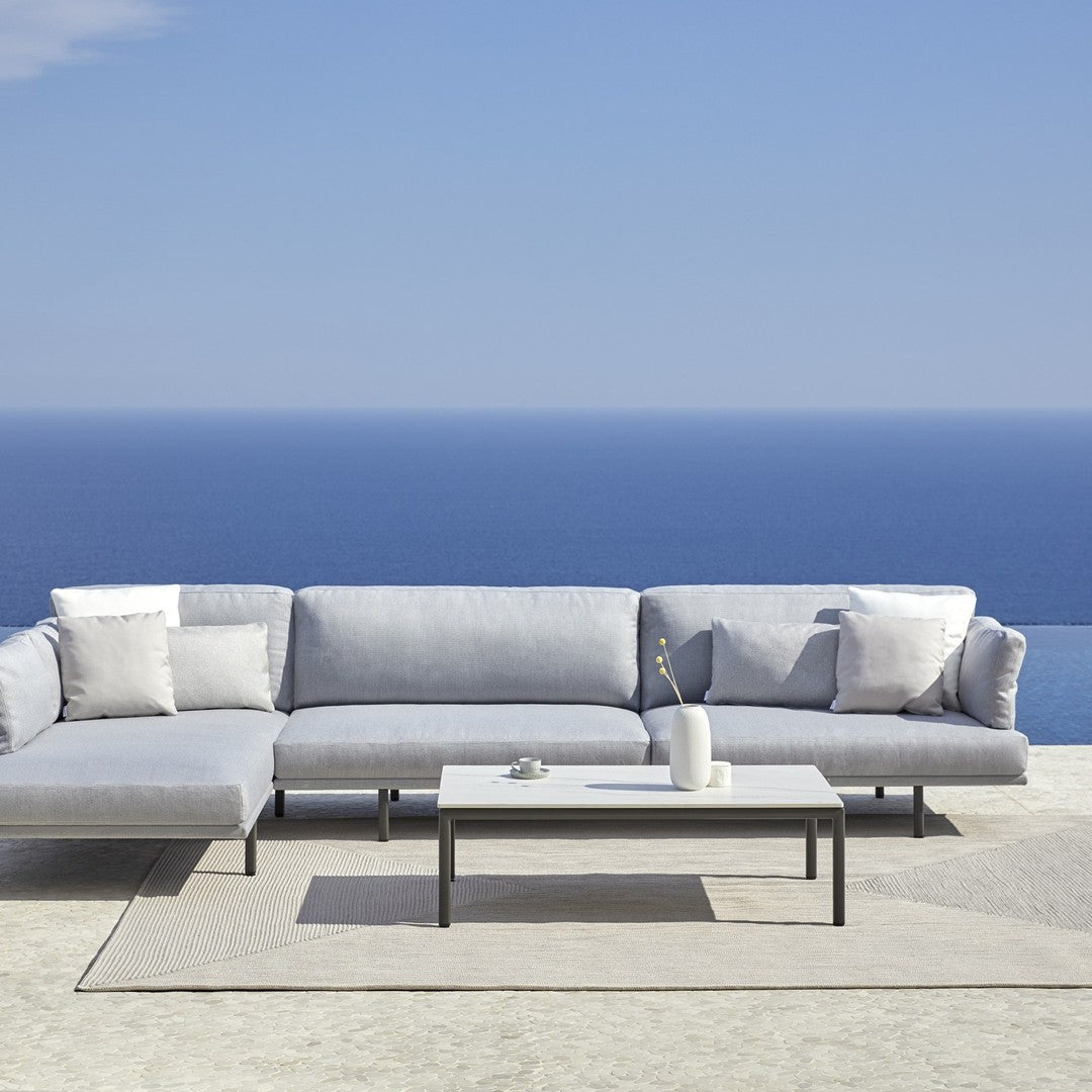 Light gray sectional sofa with sleek lines and soft textures, paired with a minimalist white coffee table.