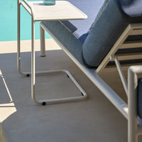 Light blue and gray lounge chair with sleek white metal frame, featuring a smooth, minimalist design.