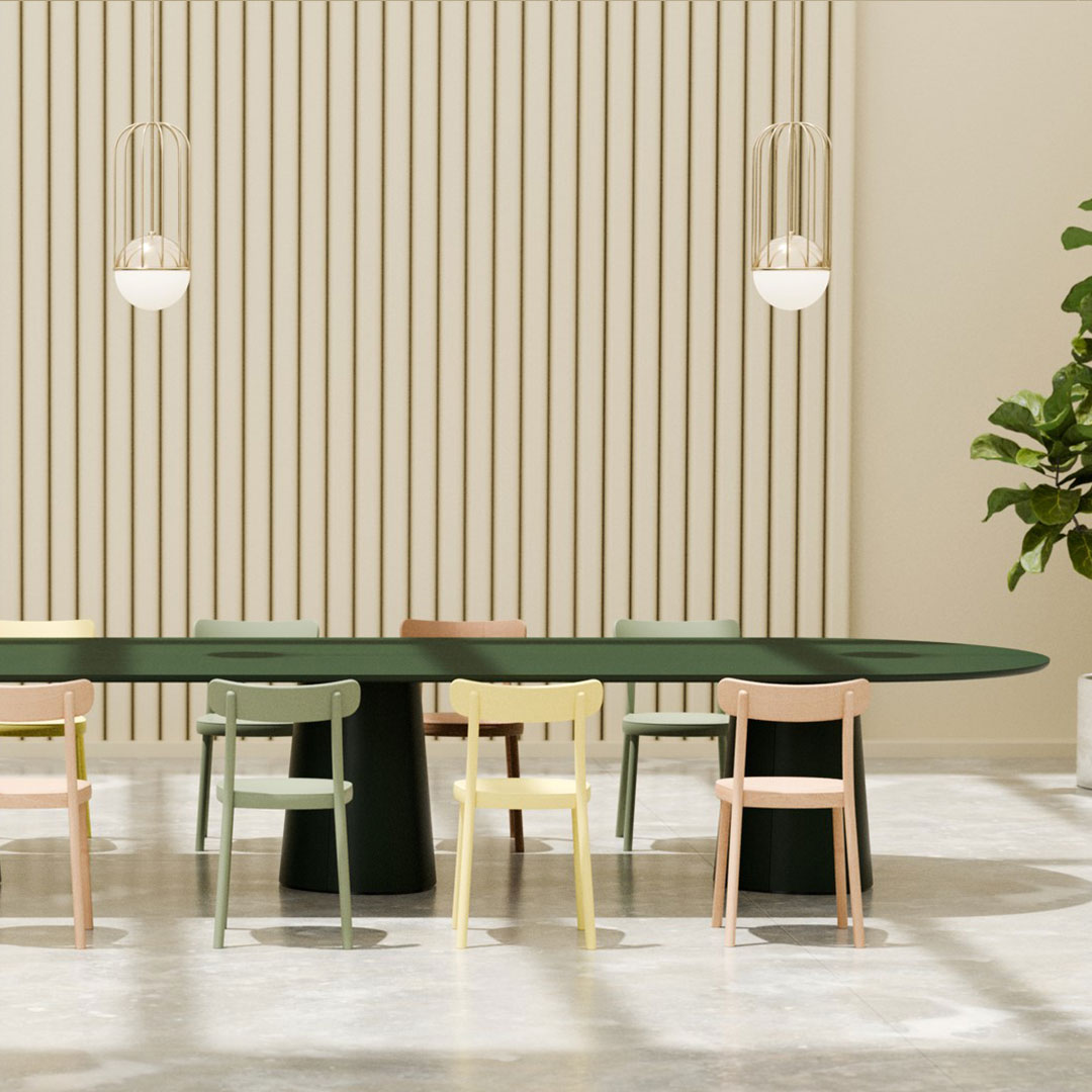 Elegant green dining table surrounded by pastel-colored chairs: pink, yellow, and light green, set against a soft beige backdrop.