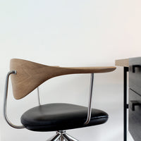 Stylish black swivel chair with a sleek wood back and modern metallic accents, perfect for contemporary decor.