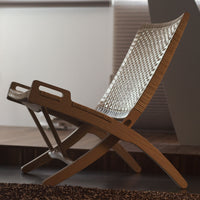 Stylish woven lounge chair in natural wood tones with a sleek, minimalist design and light-colored mesh pattern.