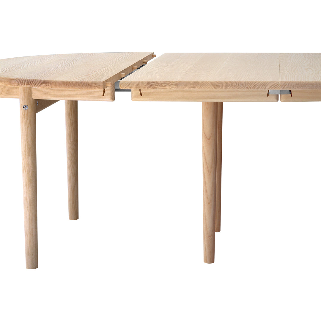 Natural wood dining table with light, beige tones and a smooth surface pattern, featuring minimalist design elements.