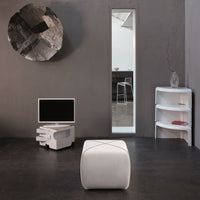 White ottoman with subtle stitching, sleek monochrome design, and modern gray wall backdrop featuring geometric art.