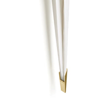 Gold accent holder with sleek white vertical rods. Modern and minimalist design for stylish decor.