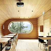 Modern wooden interior with light oak finishes, soft natural tones, and sleek black furniture accents.