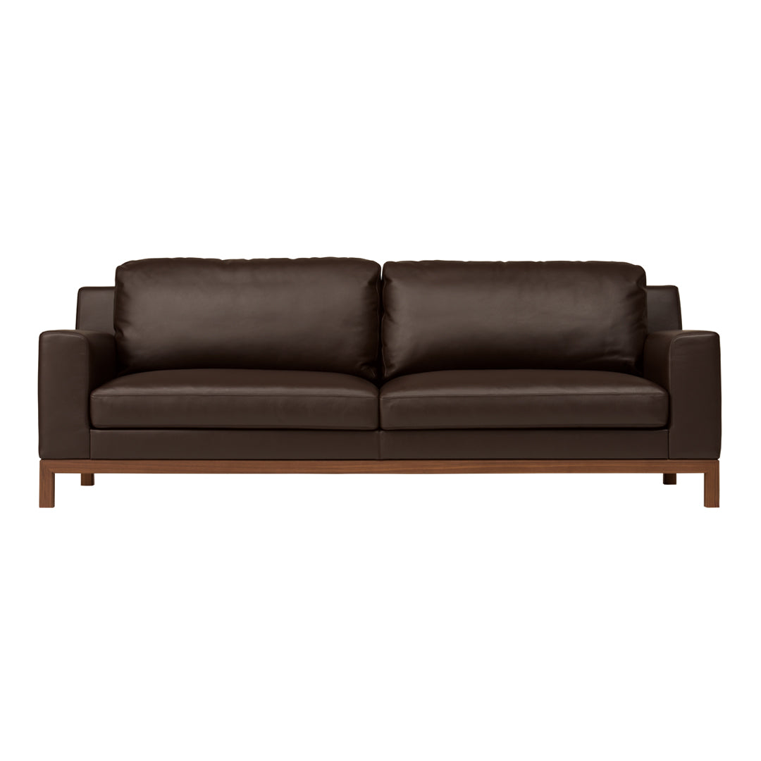 Brown leather sofa with sleek lines and wooden legs, featuring a smooth, minimalist design for modern interiors.