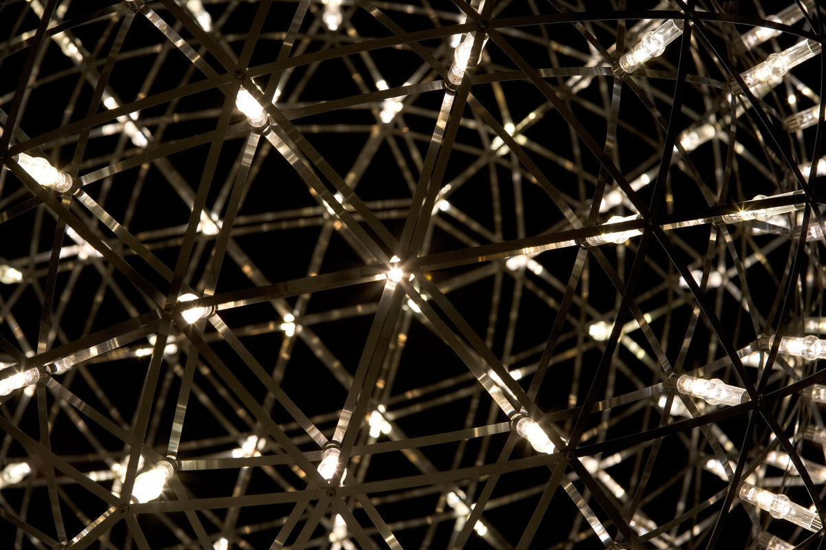 Intricate geometric pattern of gold and silver lines, illuminated against a dark background, creating a luminous effect.