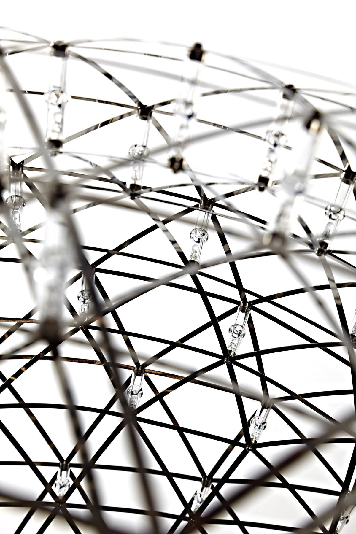Metallic black and silver wire sphere with clear crystal accents, featuring an intricate, modern geometric pattern.