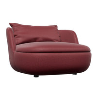 Burgundy faux leather chair with smooth surface and a plush accent pillow, featuring a modern, rounded design.
