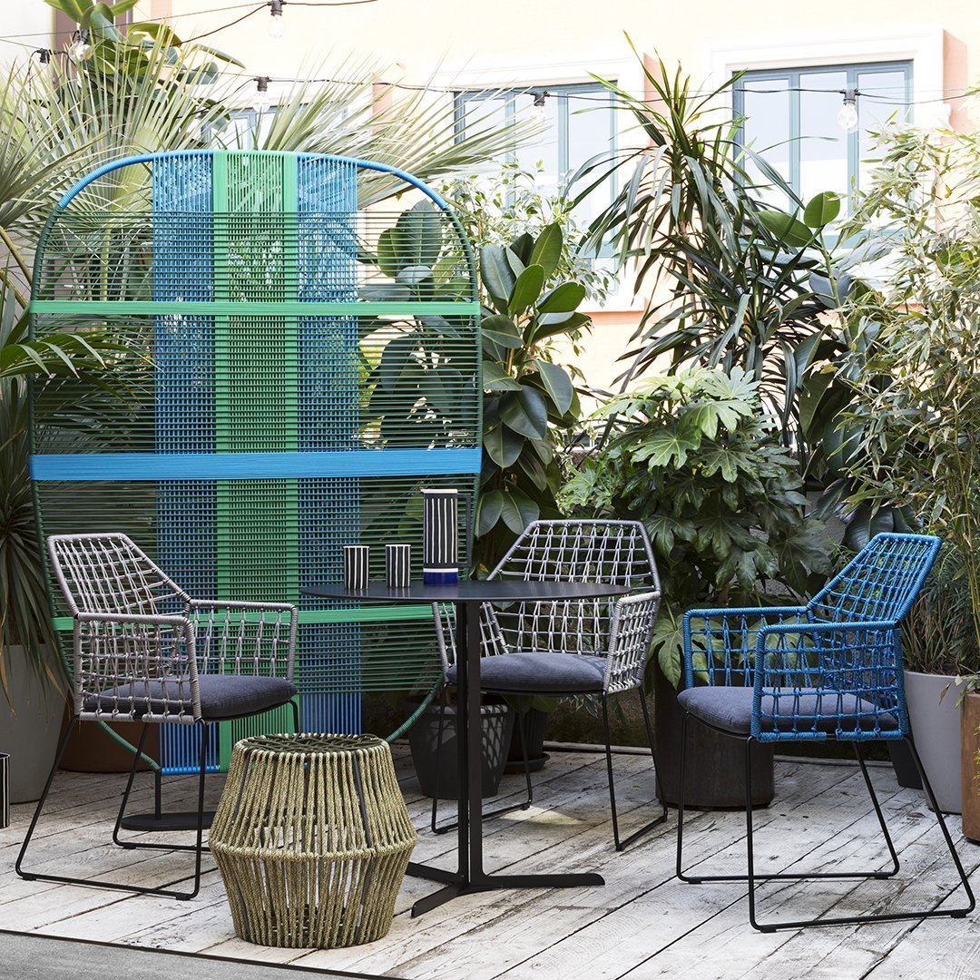 "Colorful outdoor seating set with black, grey, and blue patterns, featuring vibrant green and blue background."