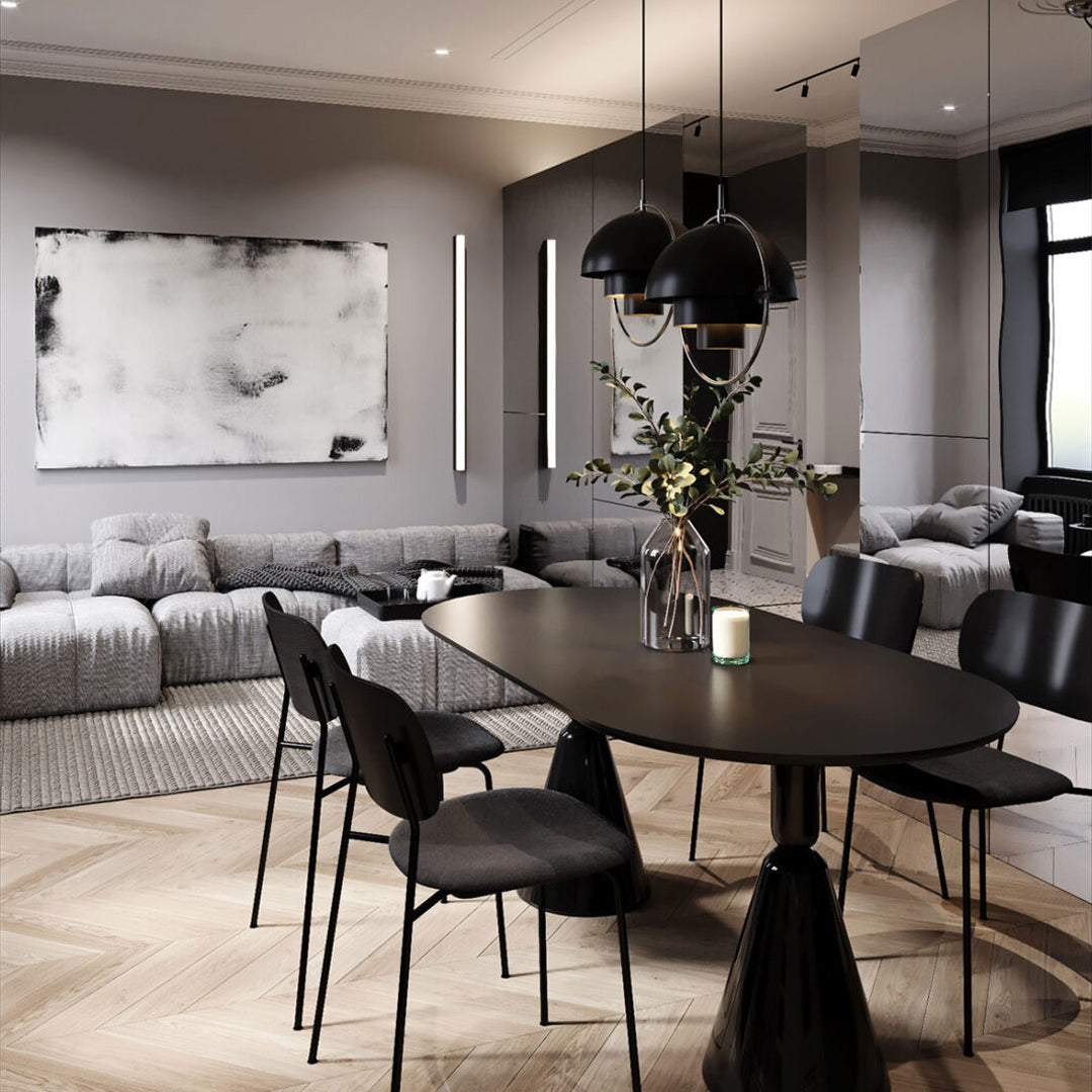 Modern dining room featuring gray walls, a black table, and black chairs, accented by light wood flooring and abstract art.