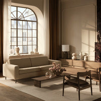 Elegant beige sofa with a light brown coffee table, complemented by neutral tones and soft texture patterns in a stylish living room.