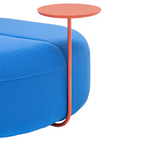 Bright blue cushion with a sleek, coral accent table. Modern, minimalist design showcasing vibrant color contrast.