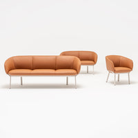 Modern orange leather sofa and chair set with sleek chrome legs, featuring a smooth, minimalist design.