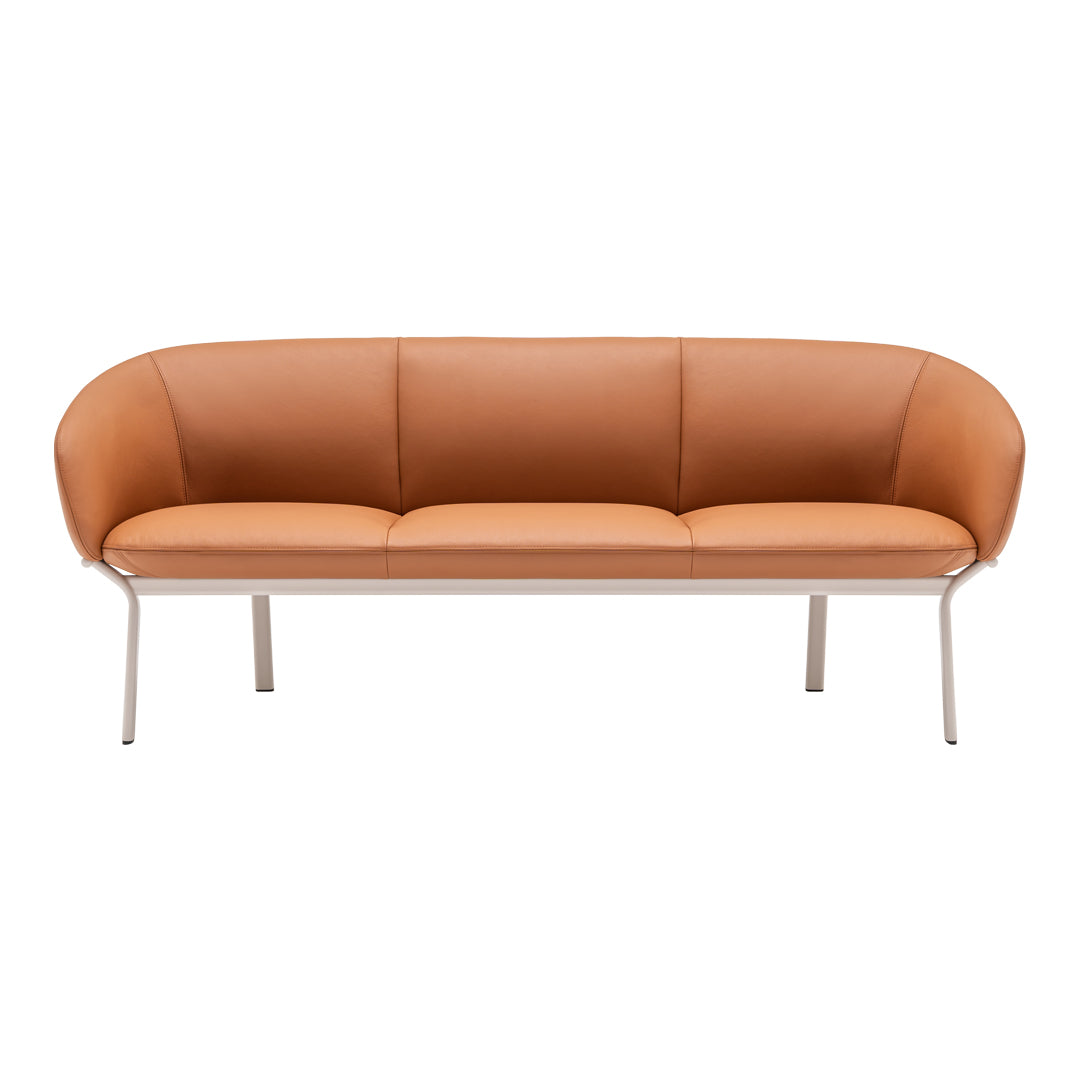 Stylish three-seater sofa in warm caramel orange with smooth leather upholstery and sleek silver legs.