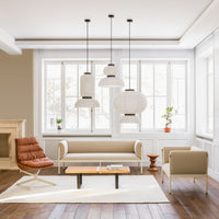 Light beige walls and furniture, brown leather chair, white decorative lamps, and a warm wood floor create a cozy atmosphere.