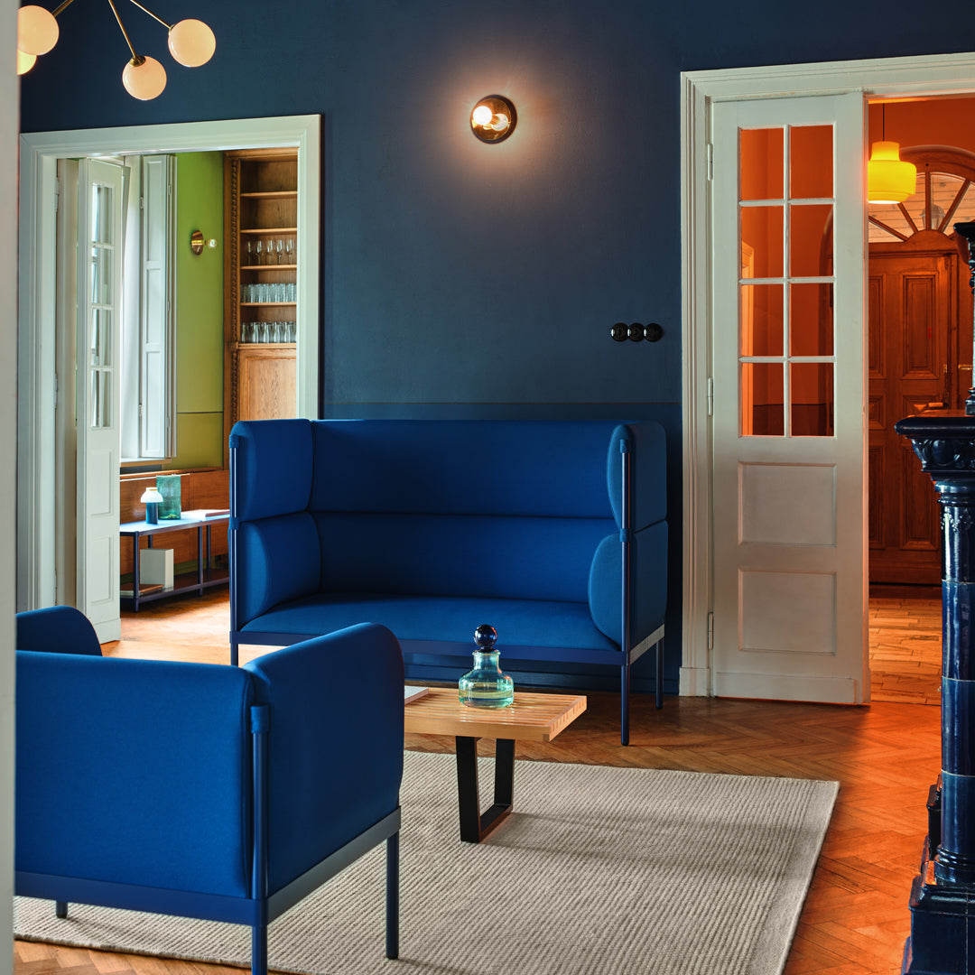 Modern blue upholstered sofas in a stylish interior with warm wood accents and a neutral rug. Bright, inviting atmosphere.
