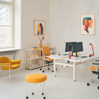 Bright yellow chairs and stools complement a modern office space with vibrant art and clean white walls.