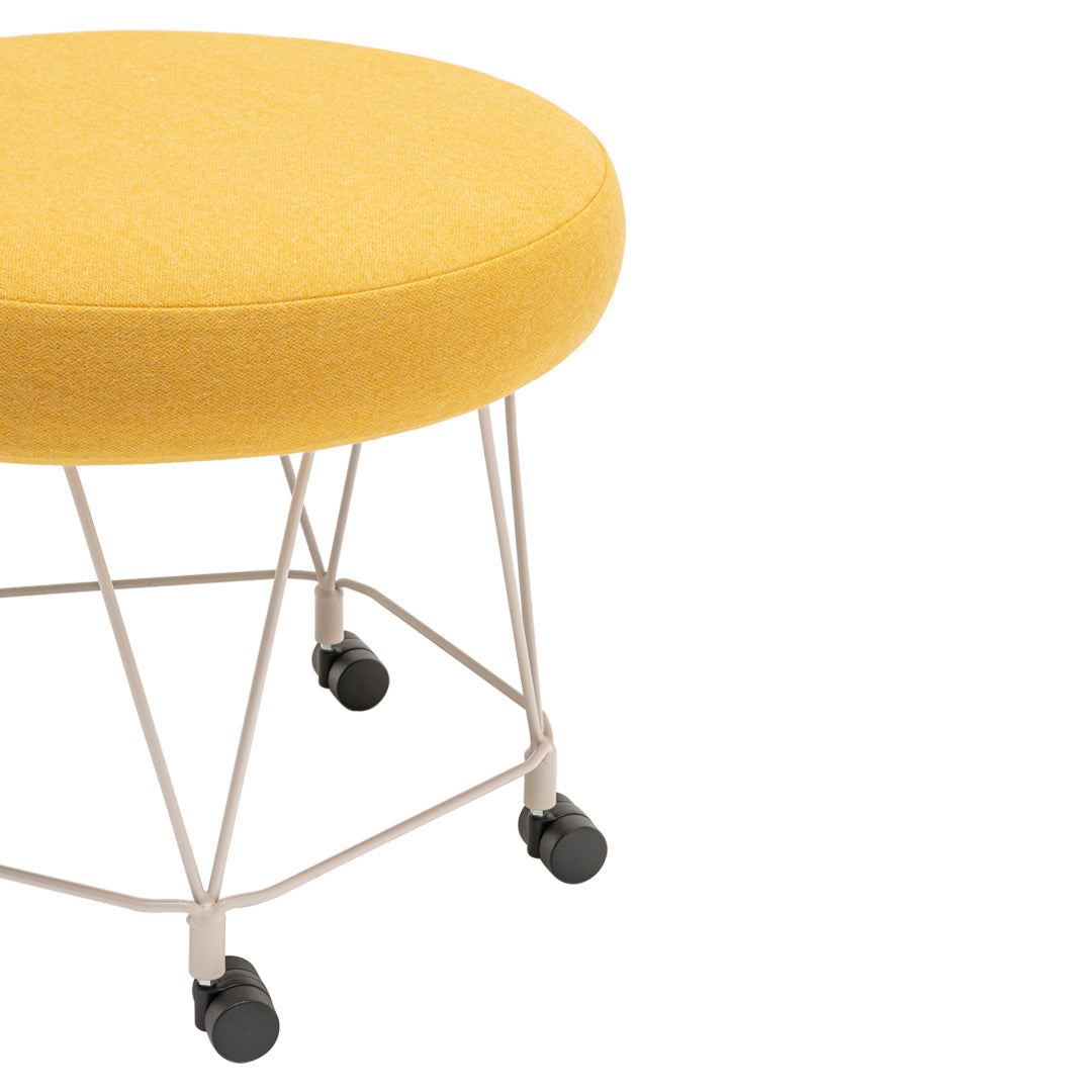 Bright yellow round ottoman with a textured fabric, supported by a sleek metal base and rolling wheels.