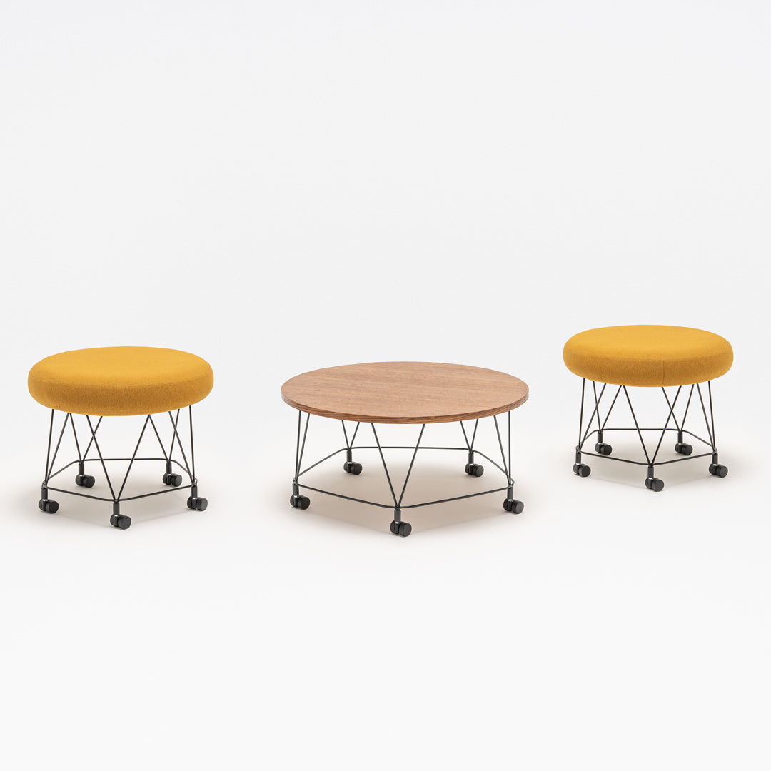 Stylish yellow upholstered stools with a round wooden coffee table; modern design and sleek black metal accents.